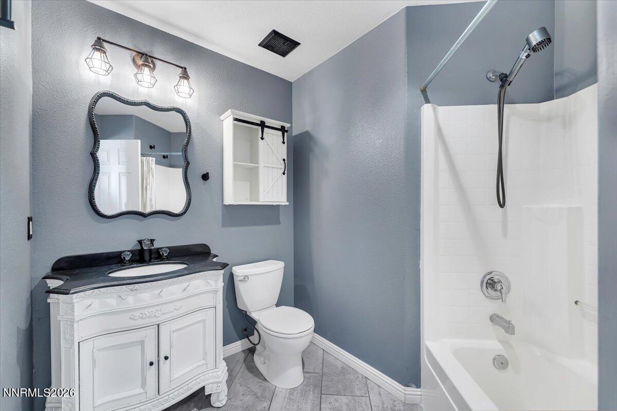 7663 La Ramba Drive Sparks, NV 89436 - Photo 19 of 27 a bathroom with a toilet sink vanity tub and mirror