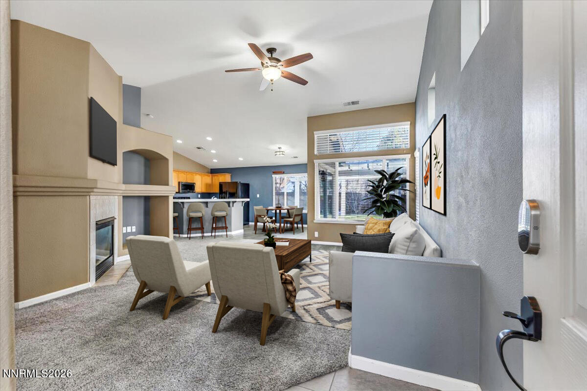 7663 La Ramba Drive Sparks, NV 89436 - Photo 4 of 27 a living room with furniture a chandelier and a dining table with wooden floor