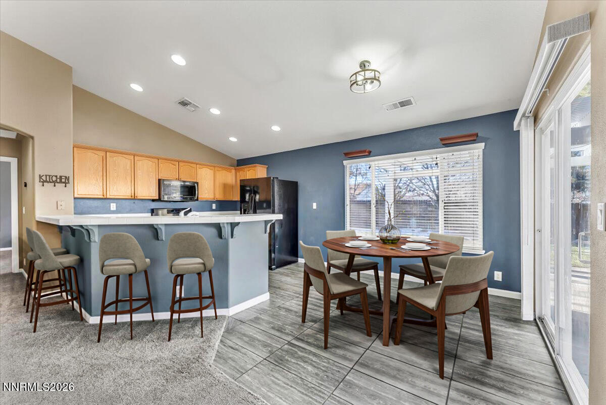 7663 La Ramba Drive Sparks, NV 89436 - Photo 8 of 27 a dining room with stainless steel appliances granite countertop a table and chairs
