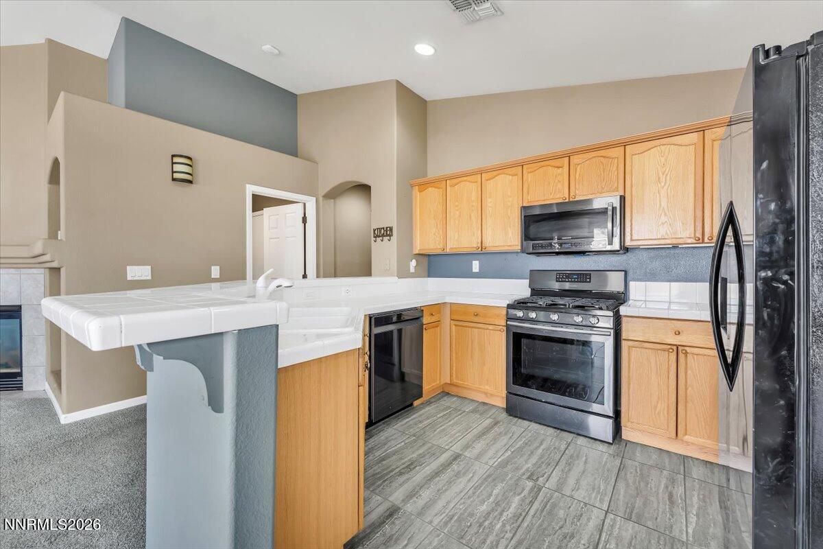 7663 La Ramba Drive Sparks, NV 89436 - Photo 10 of 27 a kitchen with stainless steel appliances kitchen island granite countertop a sink stove and refrigerator