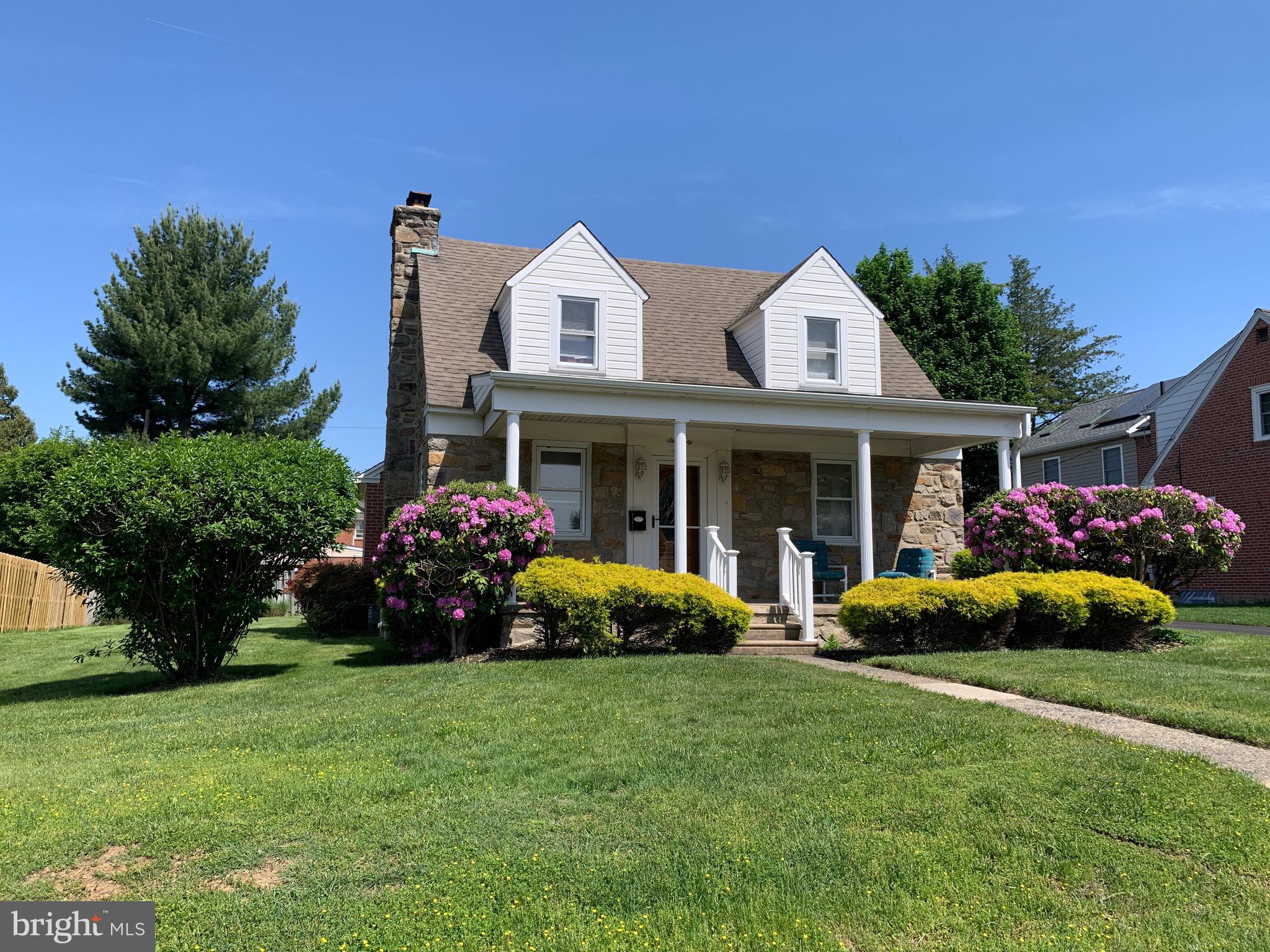 a front view of a house with garden and porch