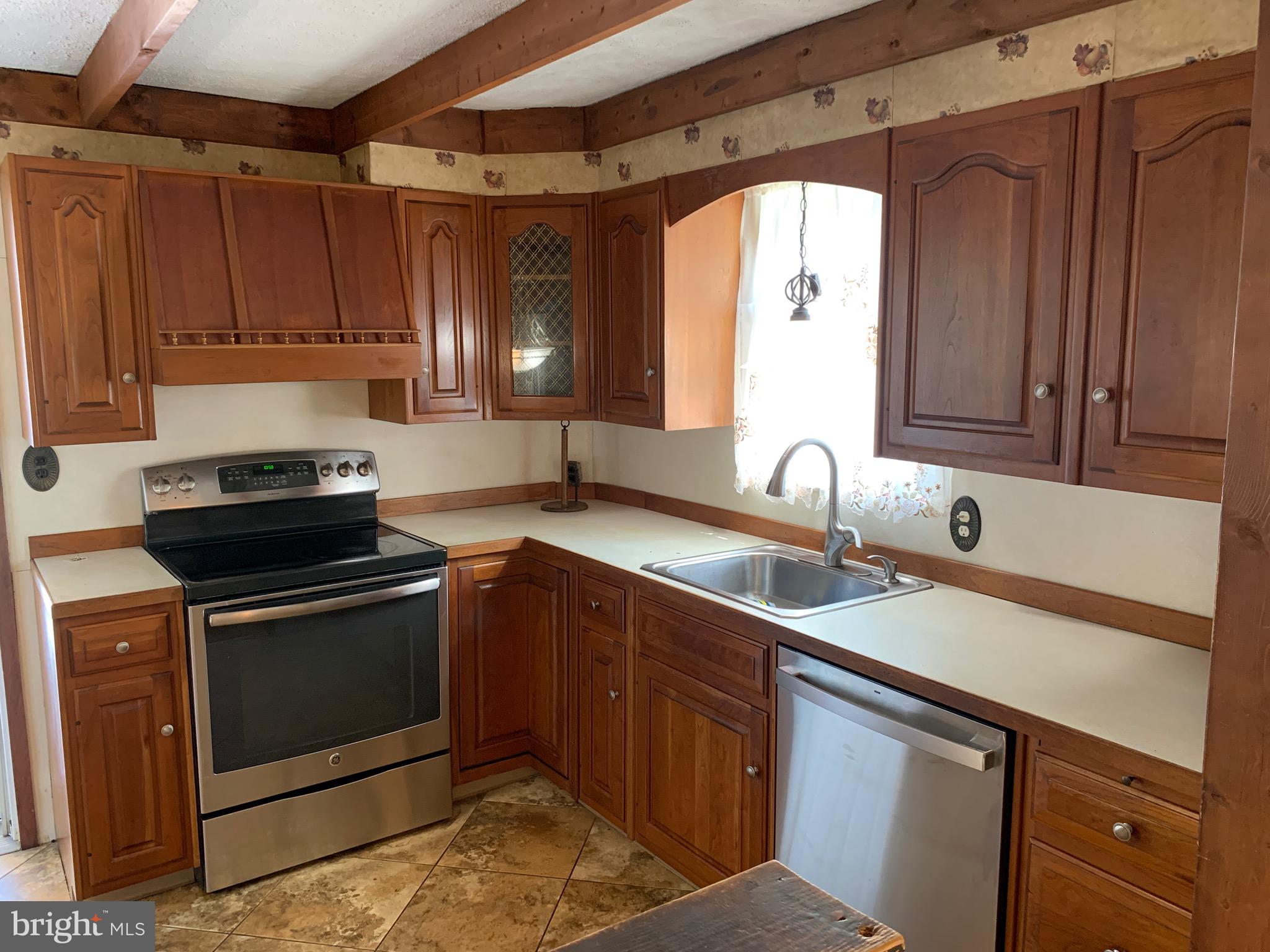 640 Laurel Road Springfield, PA 19064 - Photo 10 of 30 a kitchen with stainless steel appliances granite countertop a sink stove and cabinets