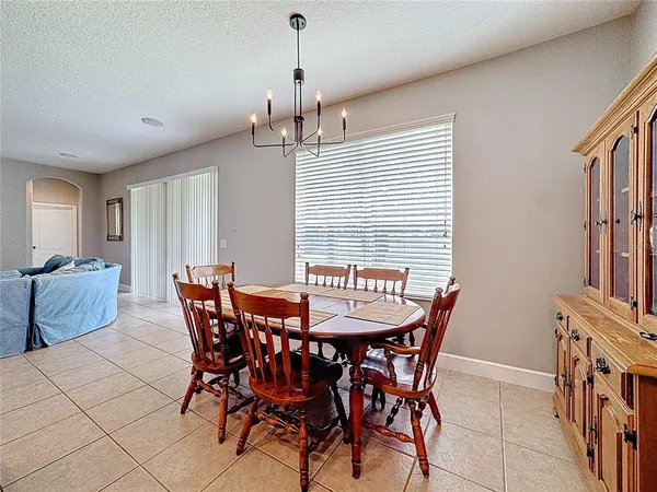 a large living room with stainless steel appliances furniture a flat screen tv and a view of kitchen