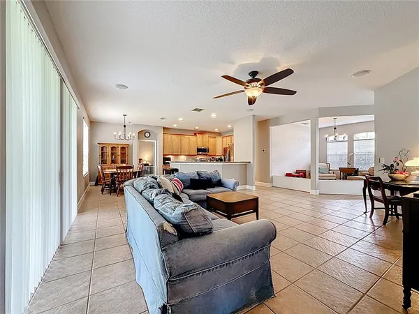 a living room with furniture a ceiling fan and a window