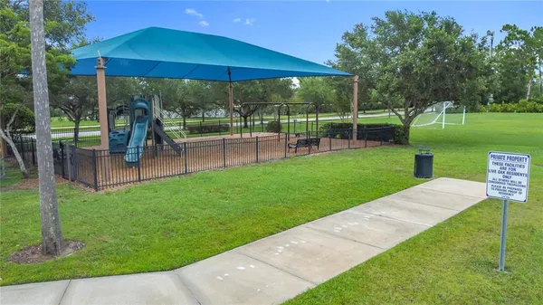 a view of a park with lawn chairs under an umbrella