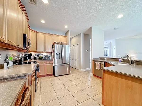 a kitchen with granite countertop a refrigerator stove top oven and sink
