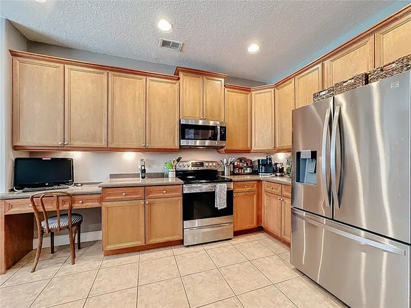 a large kitchen with granite countertop a stove top oven a sink a counter space and cabinets