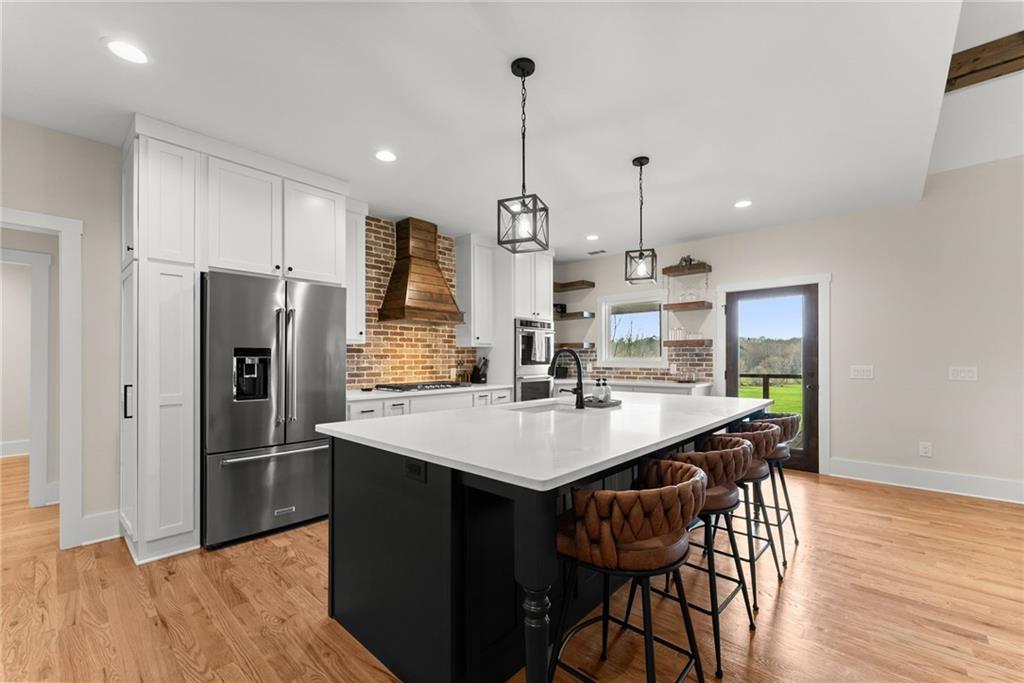 201 Fred Pitts Road Demorest, GA 30535 - Photo 18 of 55 a kitchen with stainless steel appliances kitchen island granite countertop a refrigerator a sink a stove a dining table and chairs with wooden floor