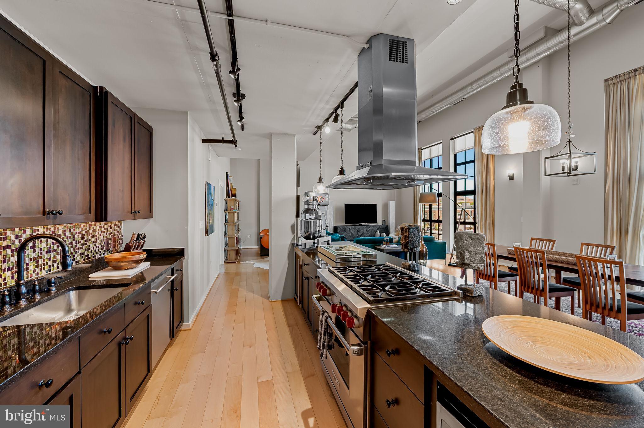 1220 Bank Street, Unit 407 Baltimore, MD 21202 - Photo 21 of 52 a kitchen with granite countertop a stove a sink and a refrigerator
