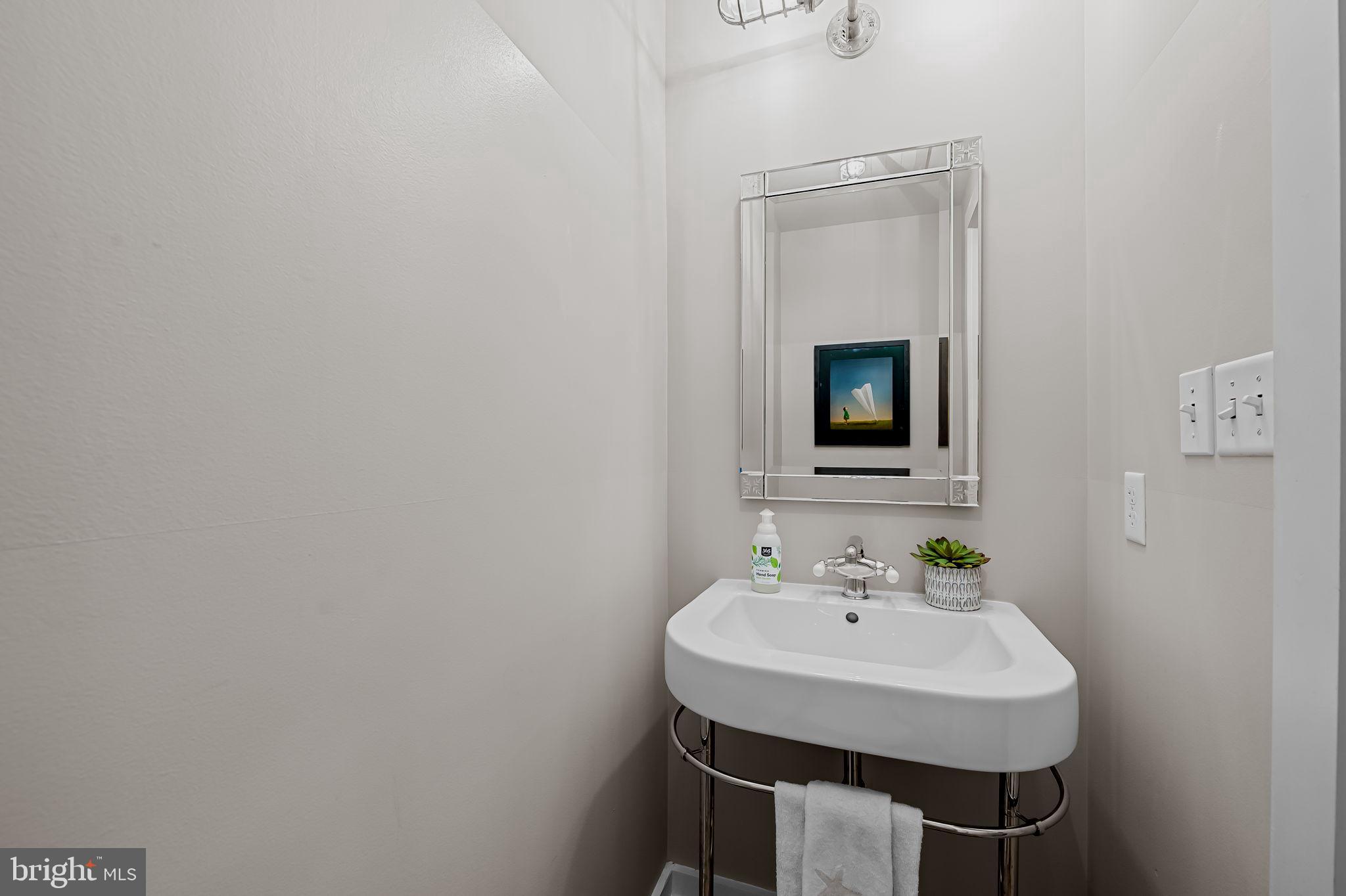 1220 Bank Street, Unit 407 Baltimore, MD 21202 - Photo 22 of 52 a bathroom with a sink and a mirror