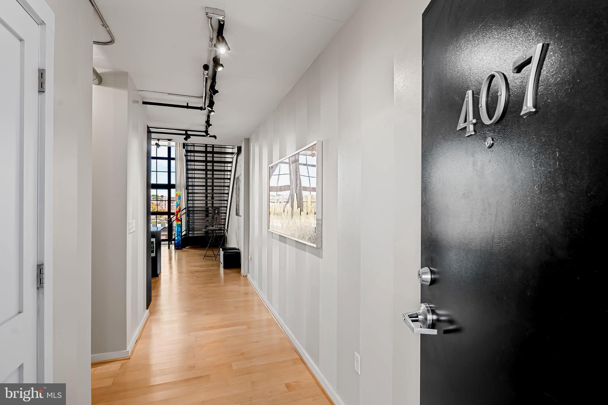 1220 Bank Street, Unit 407 Baltimore, MD 21202 - Photo 5 of 52 a view of a hallway with wooden floor and windows