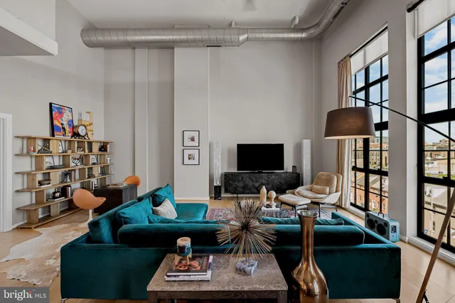 a living room with furniture and a book shelf