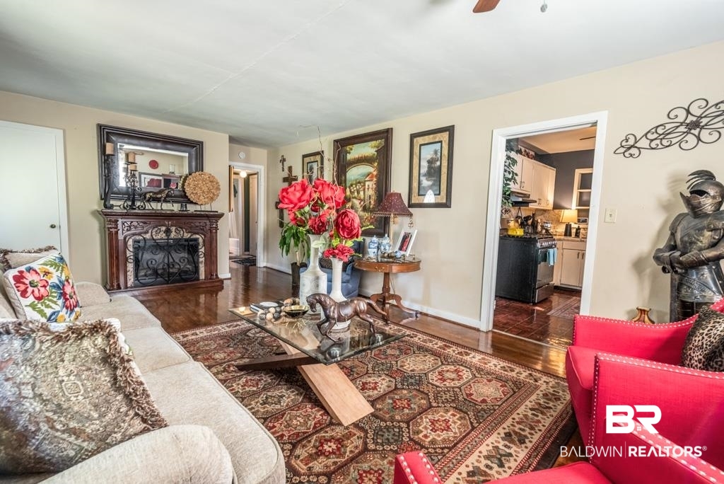 109 Esplanade Avenue Mobile, AL 36606 - Photo 7 of 45 Living room with dark wood-style flooring, a fireplace with raised hearth, and ceiling fan