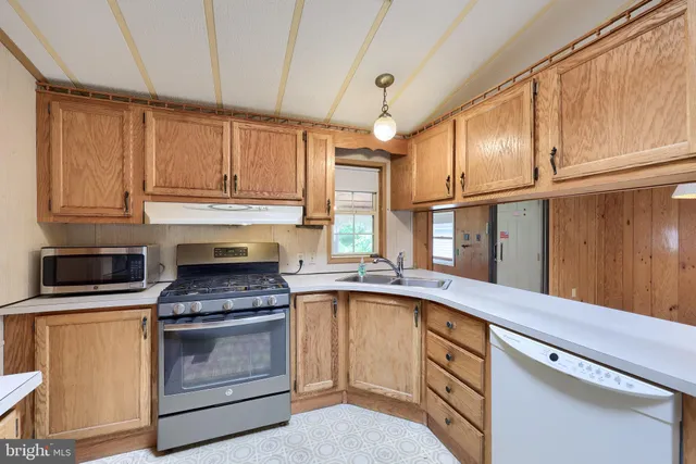 a kitchen with granite countertop a stove sink and cabinets