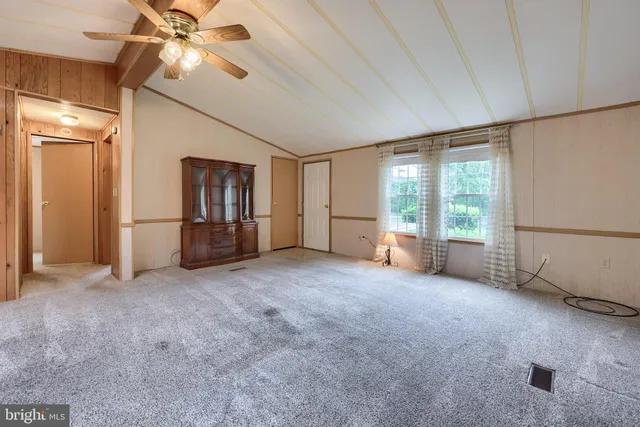 an empty room with windows and ceiling fan