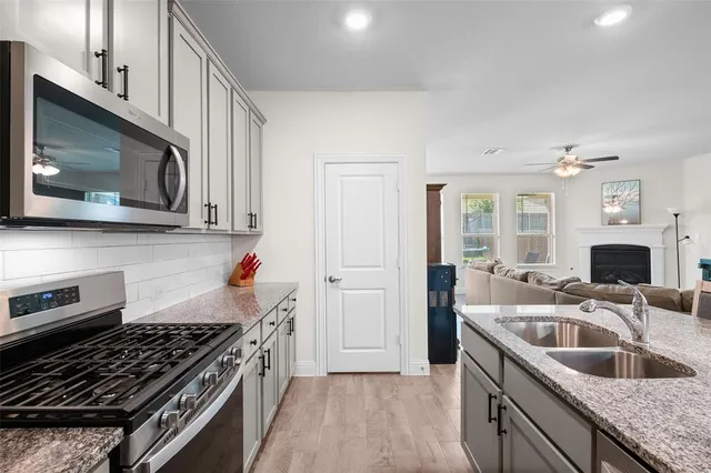 a kitchen that has a sink and a stove top oven