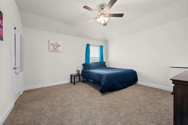 a bedroom with a bed and a ceiling fan