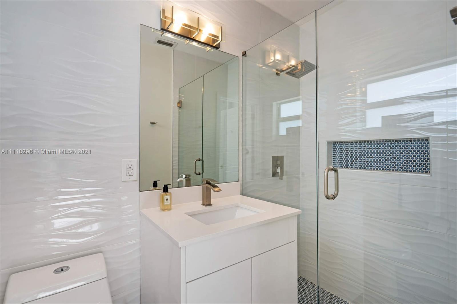 1690 Cleveland Road Miami Beach, FL 33141 - Photo 23 of 29 a bathroom with a sink a light fixture and a mirror