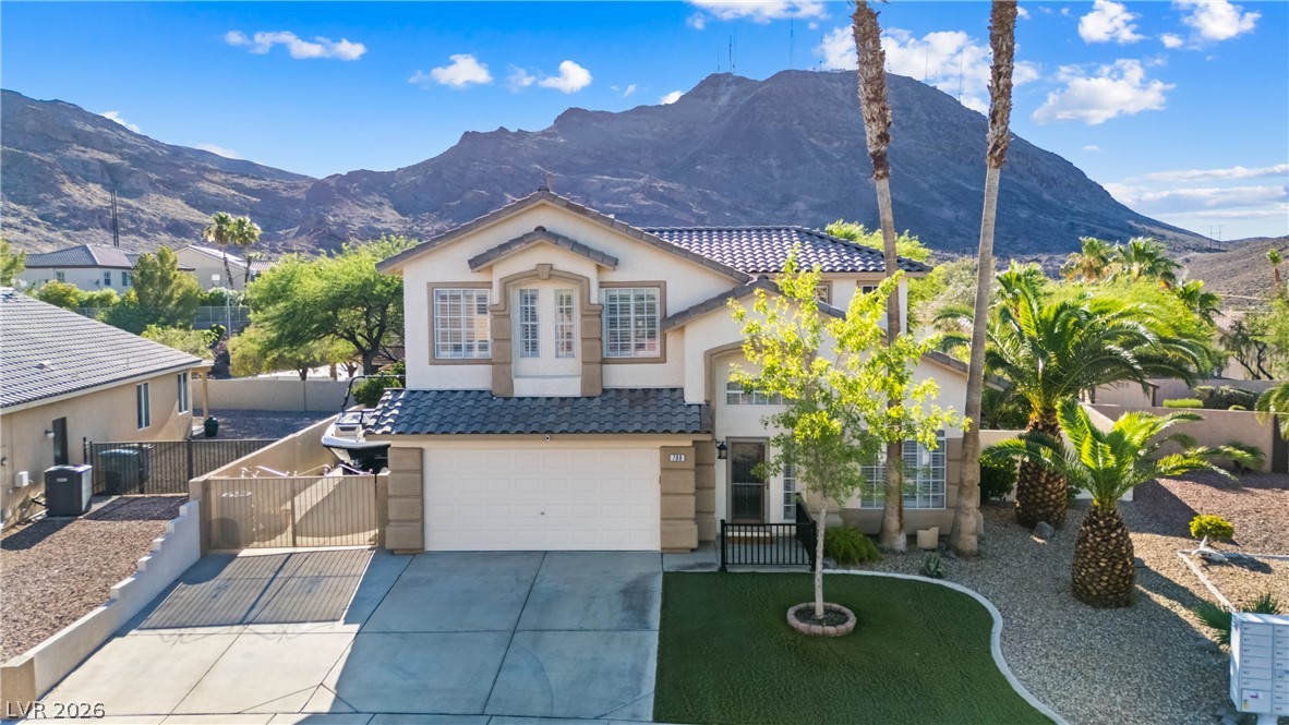 708 Vortex Avenue Henderson, NV 89002 - Photo 53 of 71 A well-kept dwelling with a spacious driveway and attached garage, set against a backdrop of majestic mountains.