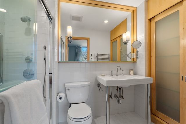 a bathroom with a sink a toilet and shower