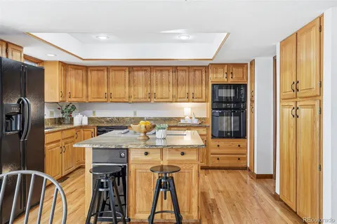 a kitchen with stainless steel appliances a refrigerator a sink and wooden cabinets