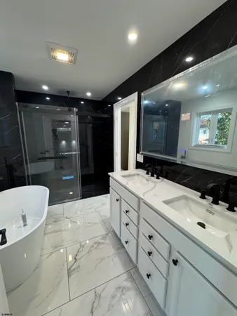 a bathroom with a sink a large mirror and a bathtub
