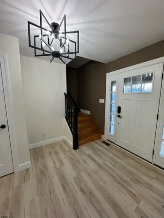 a view of a hallway with wooden floor and stairs