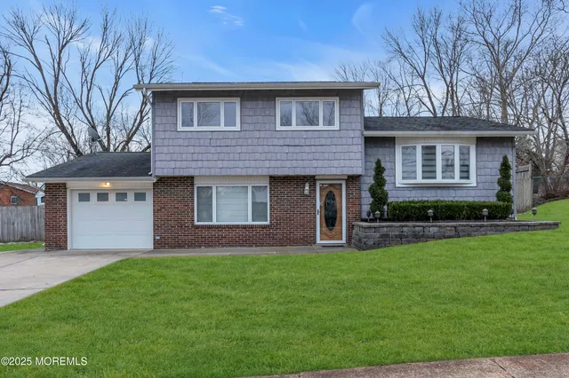 a front view of a house with a garden and yard