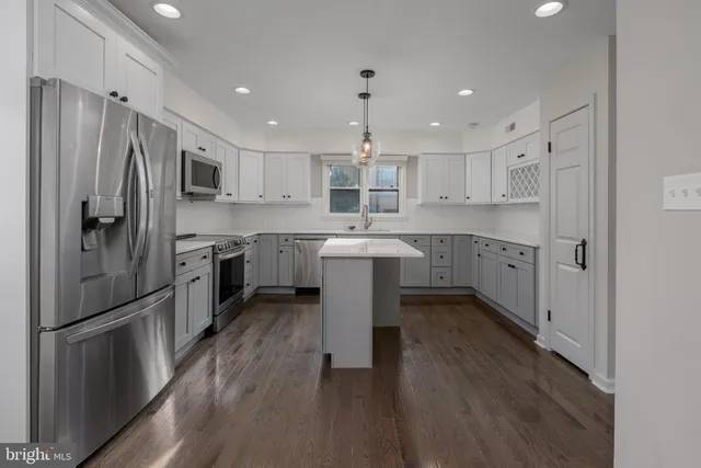 a kitchen with stainless steel appliances granite countertop a sink stove refrigerator and cabinets