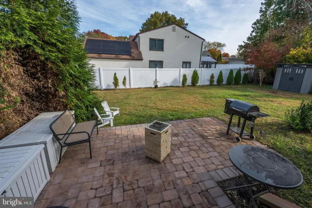 a view of a house with a backyard and a tree