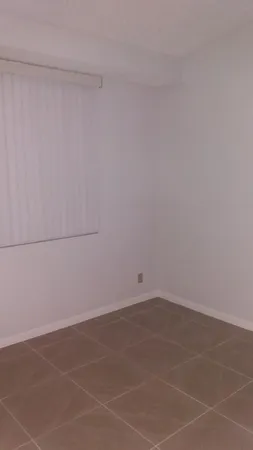 a view of an empty room with closet and a bathroom