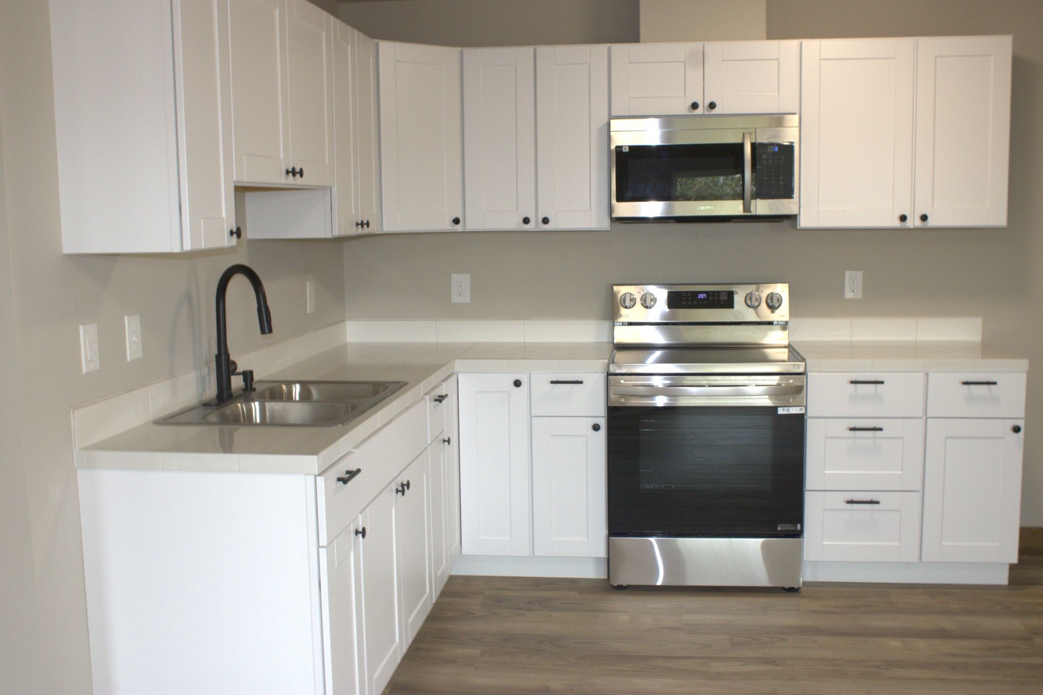 338 Road 5840 Cleveland, TX 77327 - Photo 5 of 12 a kitchen with stainless steel appliances granite countertop a stove a microwave and a white cabinets