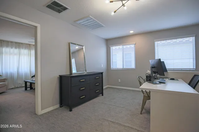 a bedroom with a bed a couch and a chandelier