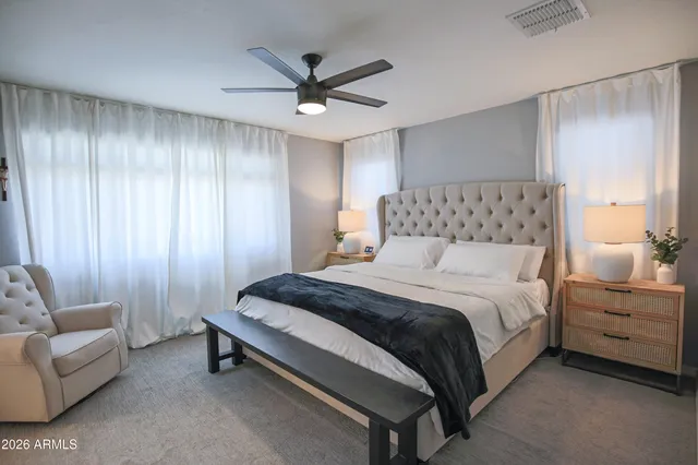 a bedroom with a large bed and a chandelier