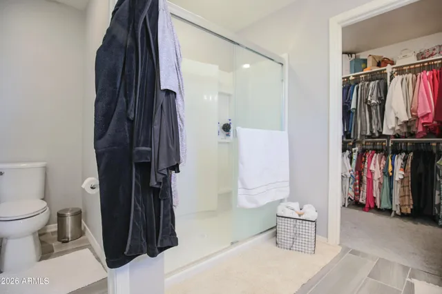 a view of walk in closet with clothes and shoes
