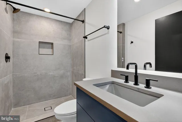 a bathroom with a sink a toilet and shower