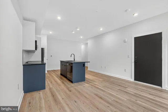 a view of kitchen with stainless steel appliances wooden floor and cabinets