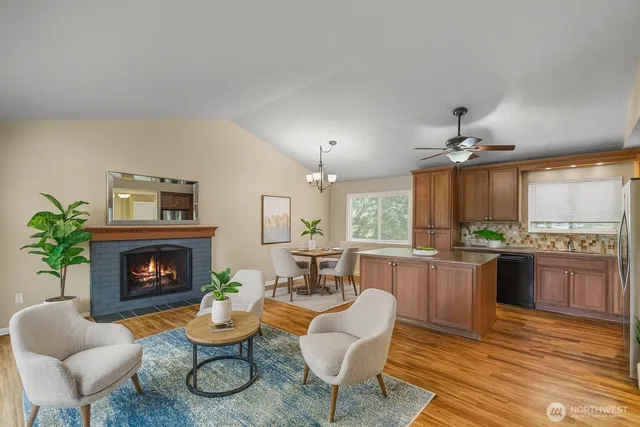 a living room with furniture a fireplace and a dining table with wooden floor