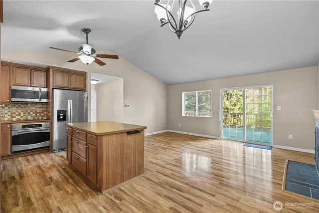 a kitchen with stainless steel appliances granite countertop a stove cabinets and wooden floor