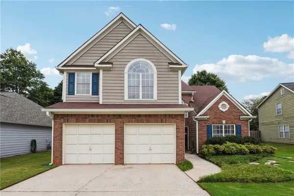 a front view of a house with a yard and garage
