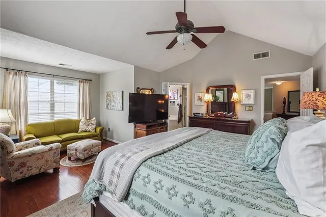 a spacious bedroom with a bed a couch and a flat screen tv