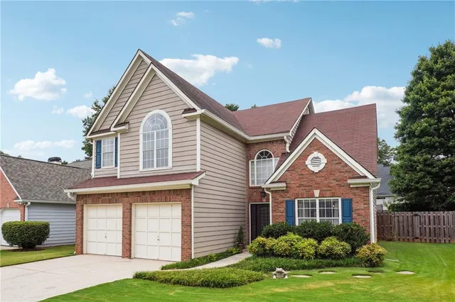 a front view of a house with a yard and garage