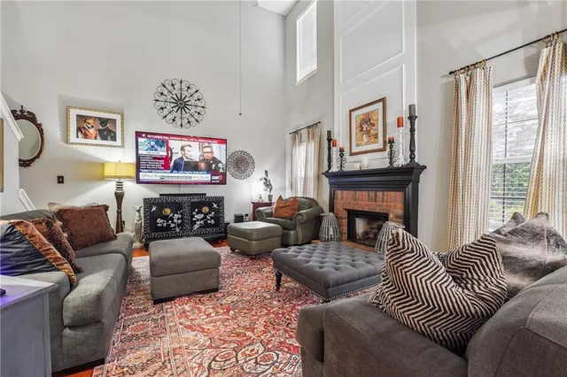 a living room with furniture a fireplace and a large window