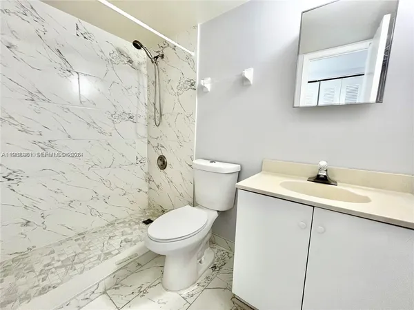 a bathroom with a sink a toilet and a shower