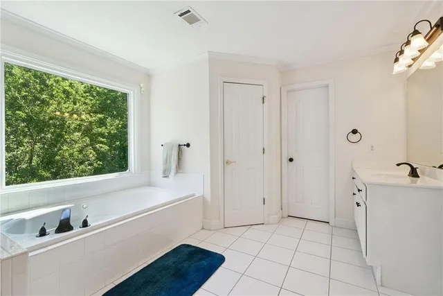 a living room with couches and kitchen view with wooden floor