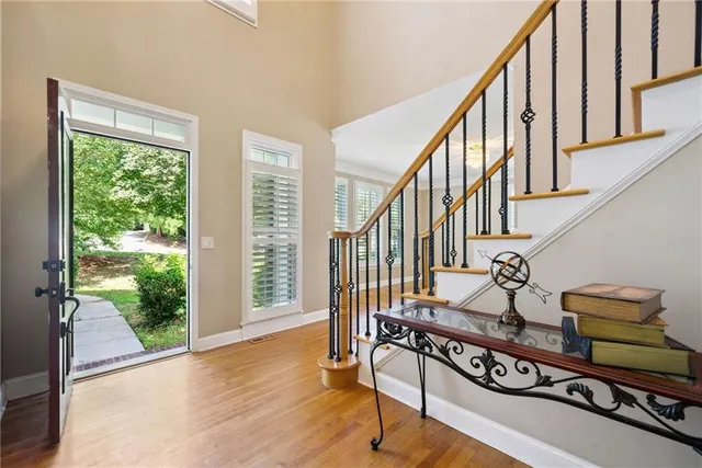 a view of a livingroom with furniture wooden floor a chandelier and a window