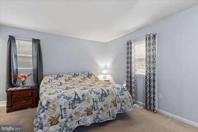 a bedroom with a bed and a dresser next to a window