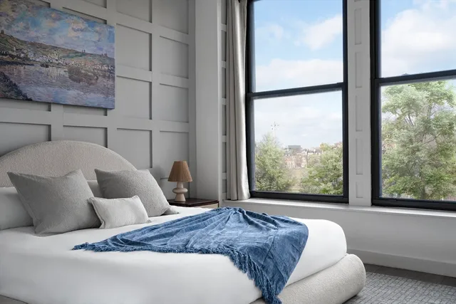 a bedroom with a bed and a large window