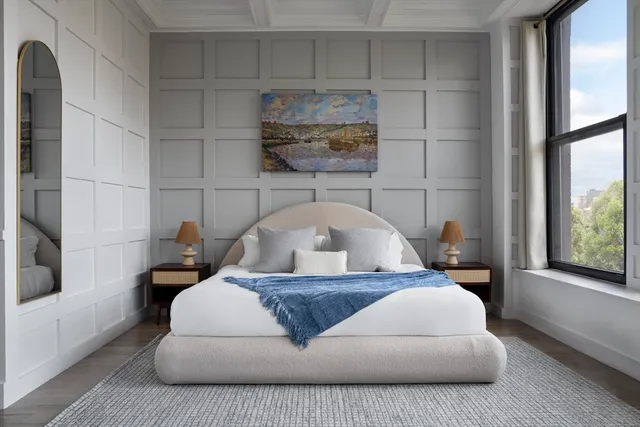 a large white bed sitting in a bathroom next to a window