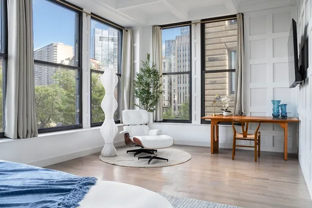 a living room with furniture a large window and a potted plant